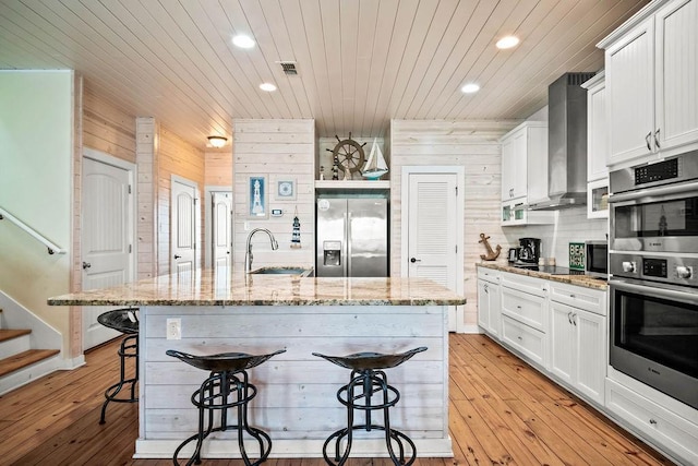 4903 State Highway 361 Unit 8, Port Aransas, TX 78373 - kitchen featuring stainless steel appliances, wall chimney exhaust hood, a kitchen bar, recessed lighting, and wood ceiling