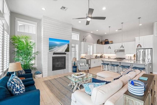 125 Reserve Ln, Rockport, TX 78382 - living area with a fireplace, ceiling fan, recessed lighting, and light wood-style flooring