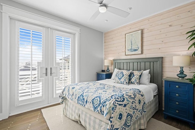 125 Reserve Ln, Rockport, TX 78382 - bedroom featuring wooden walls, access to exterior, wood finished floors, and a ceiling fan