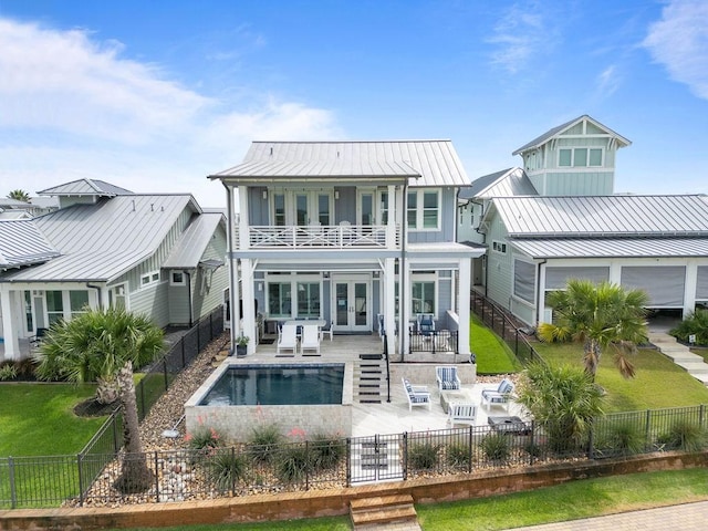 125 Reserve Ln, Rockport, TX 78382 - back of house with a balcony, a fenced backyard, french doors, a patio area, and a metal roof