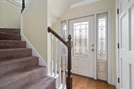 entryway featuring a barn door, stairway, and wood finished floors