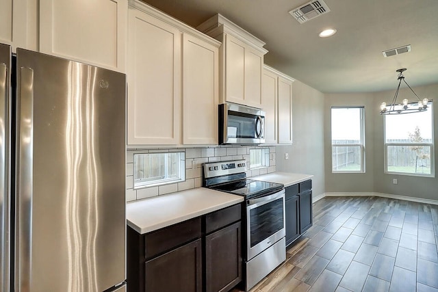 9509 Sedalia, Corpus Christi, TX 78410 - kitchen featuring appliances with stainless steel finishes, baseboards, light countertops, tasteful backsplash, and white cabinetry