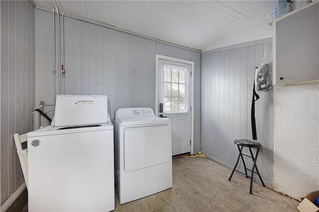 washroom featuring wood walls and washer and clothes dryer