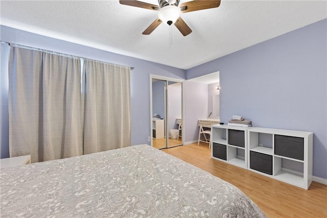 bedroom with ceiling fan, light wood-type flooring, a textured ceiling, and a closet