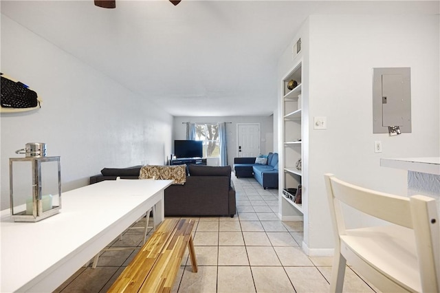 living room featuring built in shelves, light tile patterned floors, and electric panel