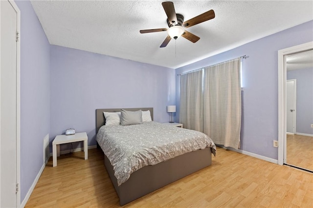 bedroom featuring a textured ceiling, light hardwood / wood-style flooring, and ceiling fan