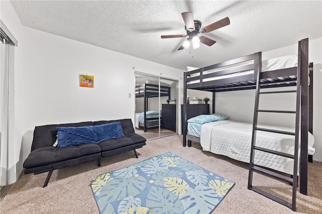 carpeted bedroom featuring a textured ceiling, a closet, and ceiling fan