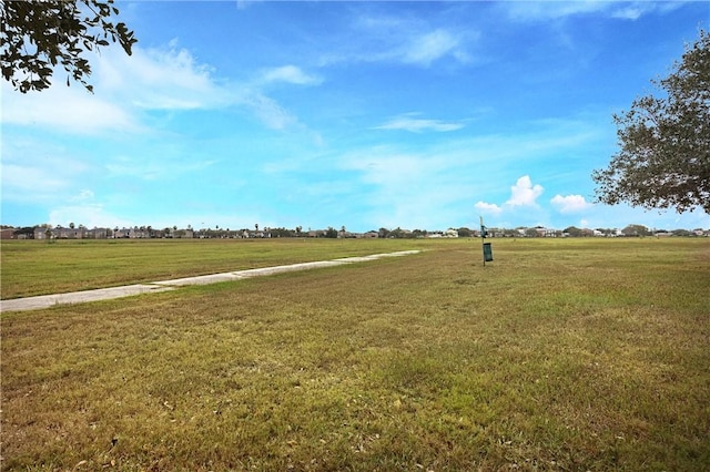 view of community with a lawn and a rural view