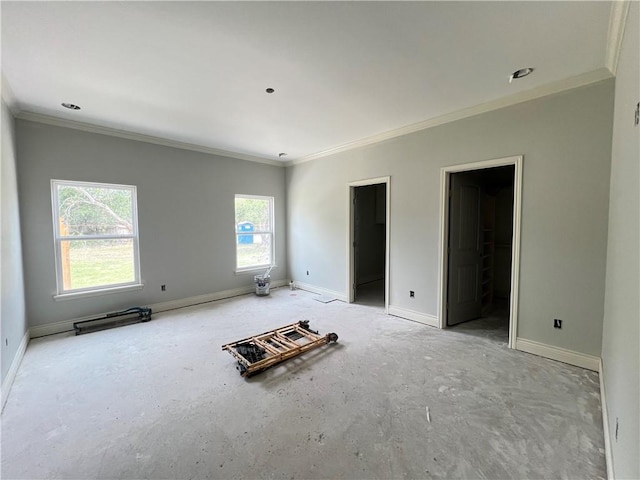 empty room featuring crown molding and baseboards