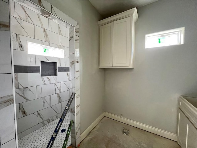 full bath featuring baseboards and a tile shower