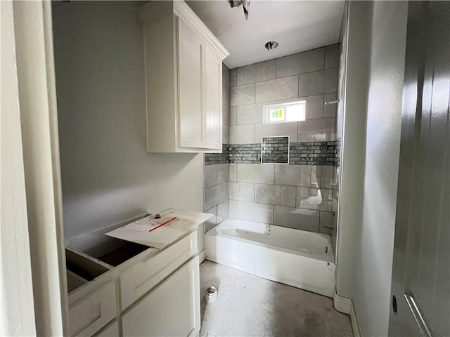 bathroom featuring concrete flooring and bathing tub / shower combination