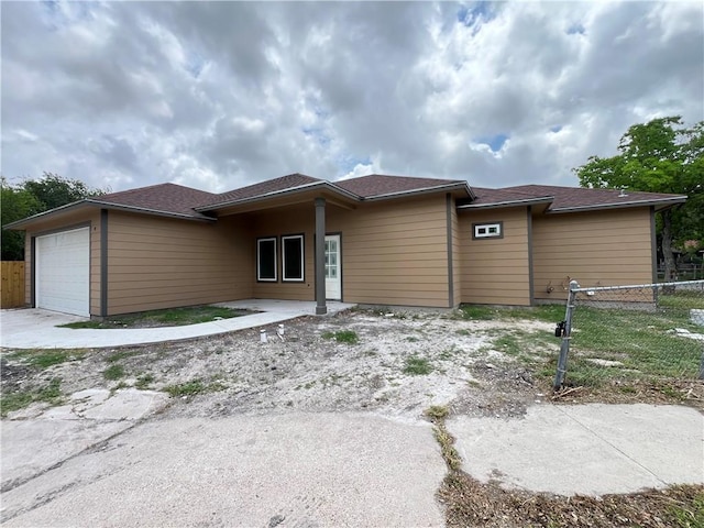 prairie-style home with fence and an attached garage