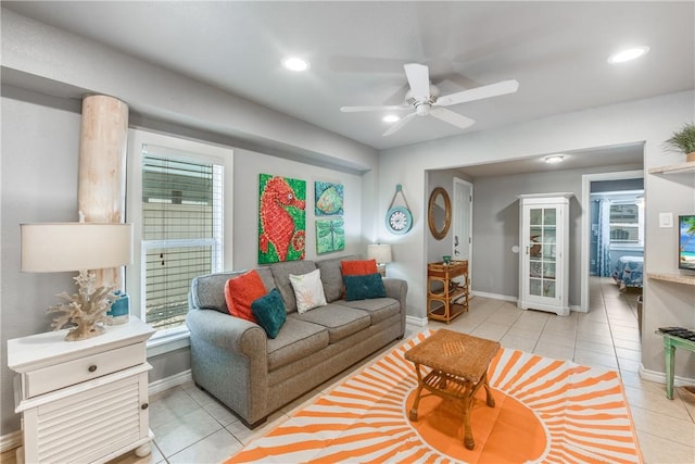 living area with light tile patterned floors, baseboards, ceiling fan, a healthy amount of sunlight, and recessed lighting