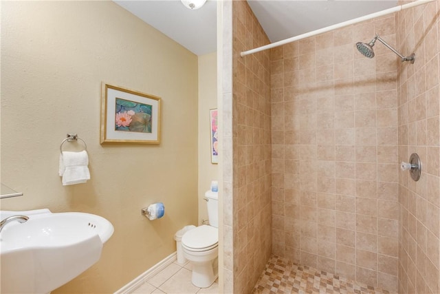 full bathroom with a sink, toilet, tiled shower, and tile patterned floors