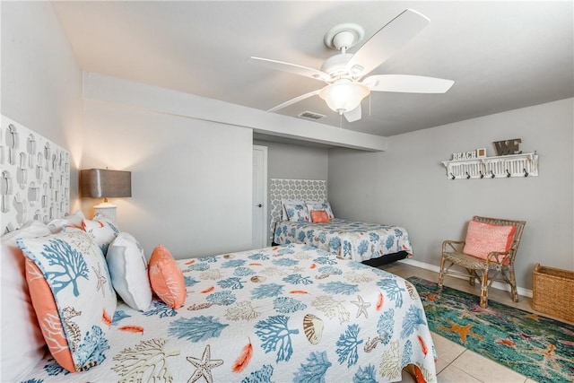 tiled bedroom featuring a ceiling fan, visible vents, and baseboards