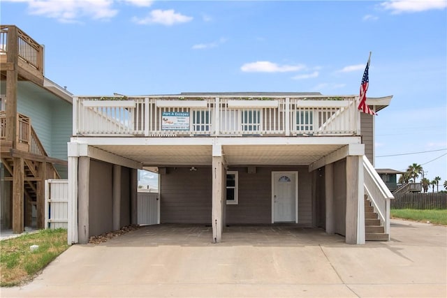 view of front facade featuring a carport, concrete driveway, and stairs