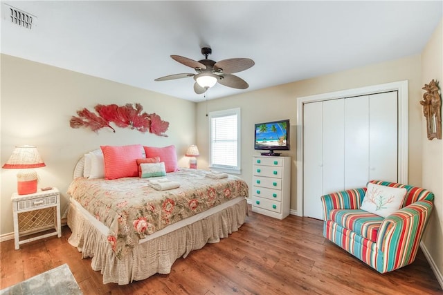 bedroom with a ceiling fan, a closet, visible vents, and wood finished floors