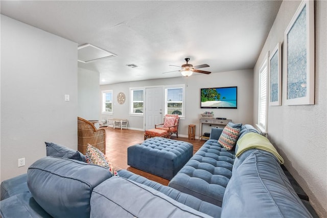 living area featuring attic access, baseboards, visible vents, ceiling fan, and wood finished floors