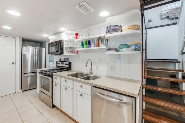 kitchen featuring open shelves, stainless steel appliances, a sink, and light tile patterned flooring