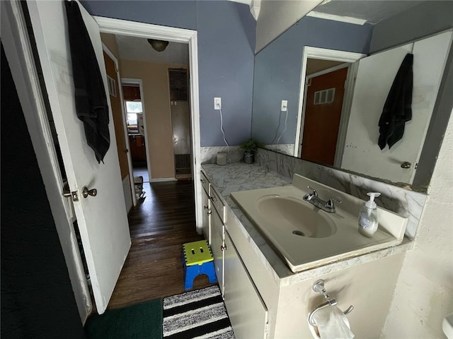 bathroom featuring baseboards, vanity, visible vents, and wood finished floors