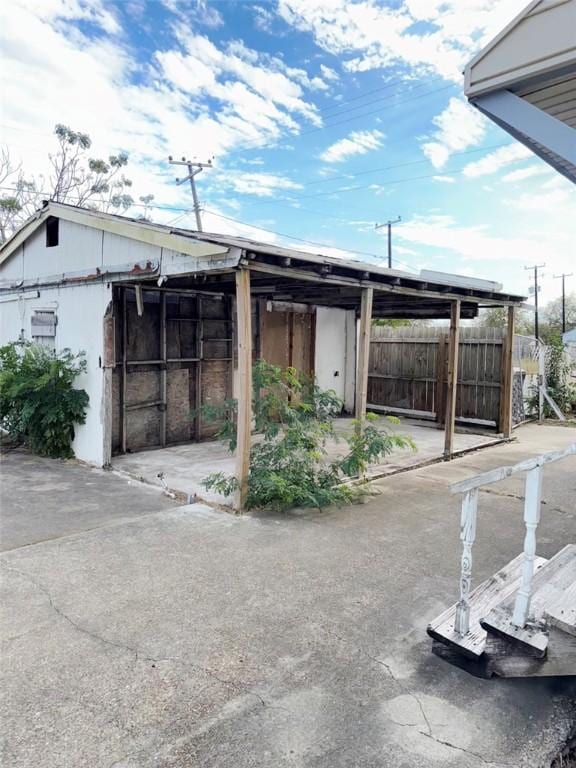 exterior space featuring a carport and fence