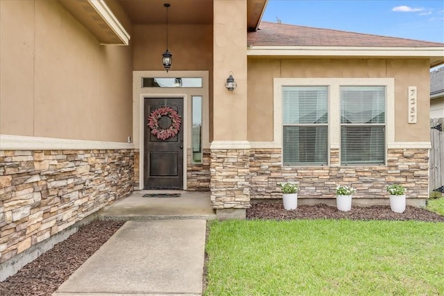 7237 Lake Tranquility Dr, Corpus Christi, TX 78414 - doorway to property featuring stucco siding, a yard, and stone siding