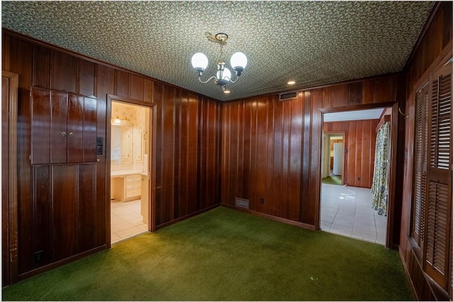 interior space featuring an inviting chandelier, dark carpet, and wooden walls