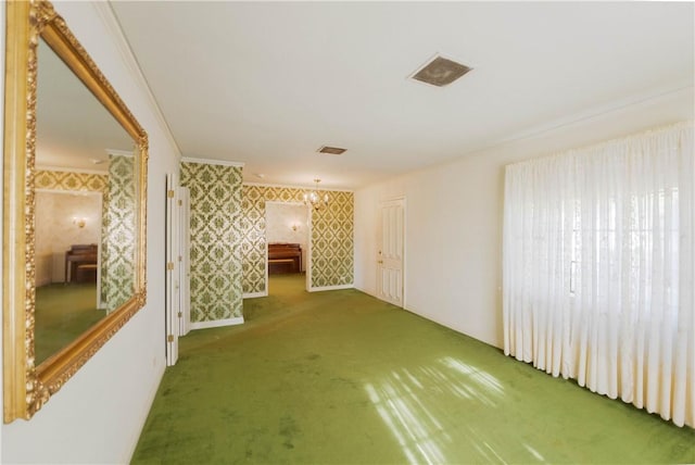 hallway with ornamental molding and carpet flooring