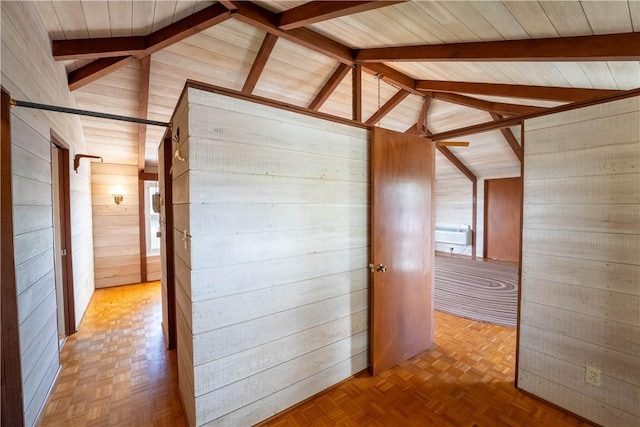 corridor with vaulted ceiling with beams, wooden walls, and light parquet floors