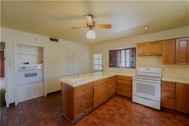 kitchen featuring sink, white appliances, ceiling fan, a textured ceiling, and kitchen peninsula