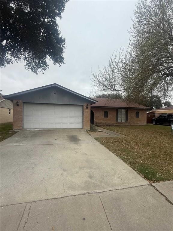 ranch-style house featuring driveway, an attached garage, and brick siding