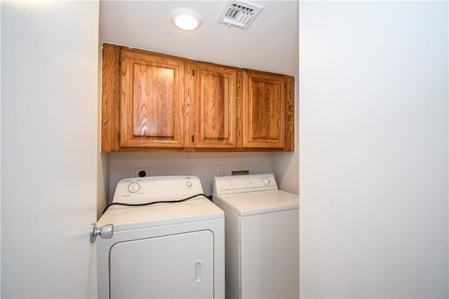 washroom featuring cabinets and washing machine and dryer