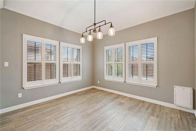 14150 Coquina Bay Ave, Corpus Christi, TX 78418 - spare room featuring baseboards, light wood-style floors, and an inviting chandelier