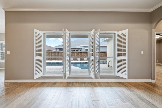 14150 Coquina Bay Ave, Corpus Christi, TX 78418 - doorway to outside with arched walkways, baseboards, ornamental molding, and wood finished floors