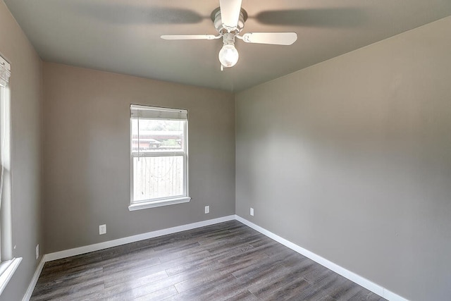 empty room with dark wood-style floors, baseboards, and a ceiling fan