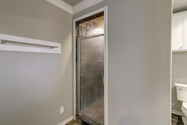 full bathroom featuring toilet, a shower stall, baseboards, and crown molding