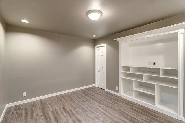 spare room with recessed lighting, wood finished floors, and baseboards