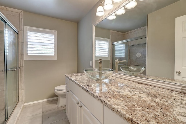 full bath featuring a stall shower, baseboards, toilet, tile patterned flooring, and vanity