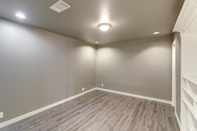 unfurnished room with recessed lighting, visible vents, baseboards, and wood finished floors