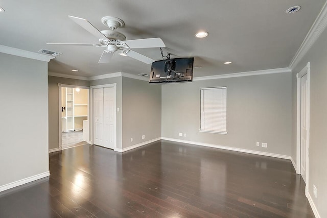 spare room featuring baseboards, visible vents, wood finished floors, and ornamental molding