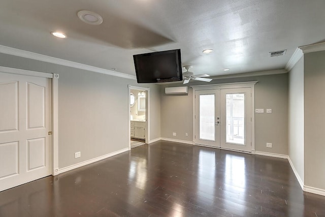 unfurnished living room featuring wood finished floors, visible vents, an AC wall unit, ornamental molding, and french doors