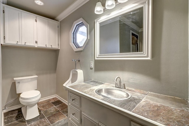 bathroom with stone finish floor, baseboards, vanity, and toilet