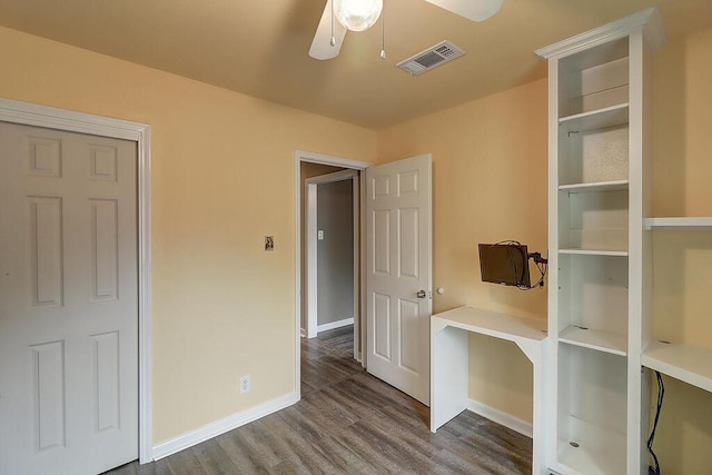 unfurnished bedroom with ceiling fan, baseboards, visible vents, and dark wood finished floors