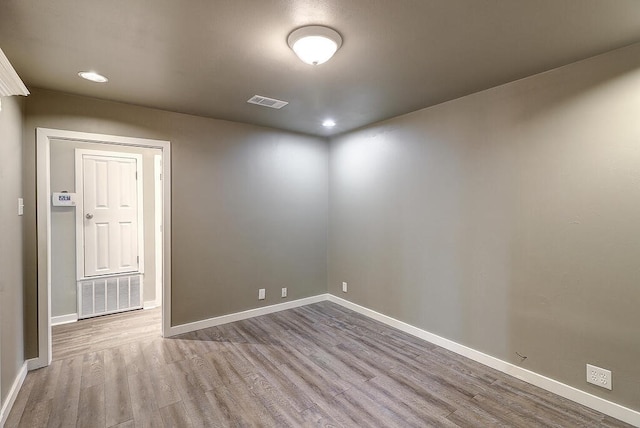 empty room with visible vents, baseboards, wood finished floors, and recessed lighting