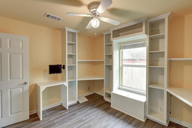 unfurnished office featuring baseboards, wood finished floors, visible vents, and a ceiling fan