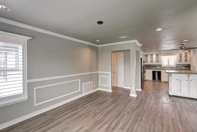 kitchen with black dishwasher, crown molding, white cabinets, and dark wood finished floors