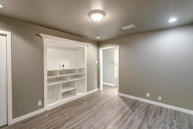 spare room with visible vents, baseboards, and wood finished floors