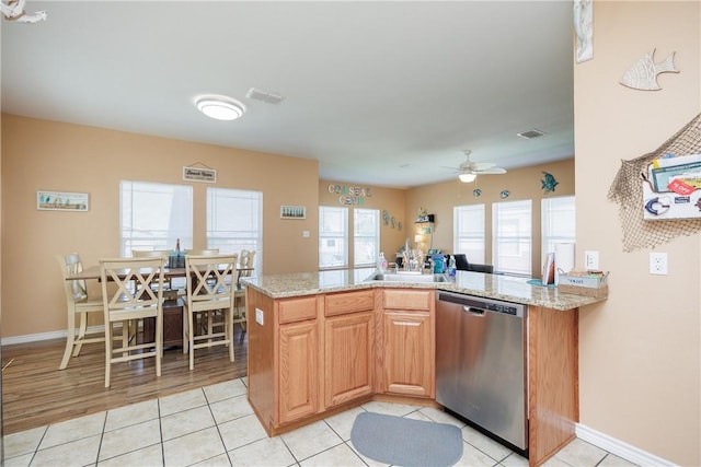 kitchen featuring light stone countertops, ceiling fan, stainless steel dishwasher, kitchen peninsula, and light tile patterned floors