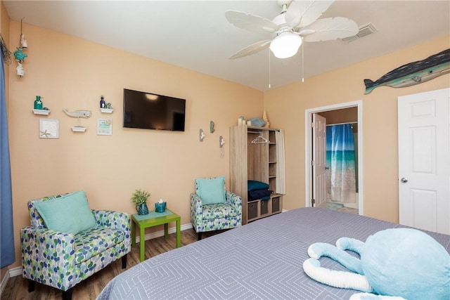 bedroom with ceiling fan, dark hardwood / wood-style flooring, and ensuite bathroom