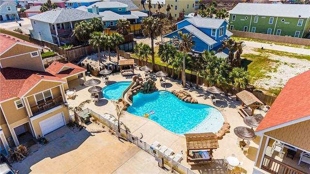 community pool with a residential view, a patio, and fence